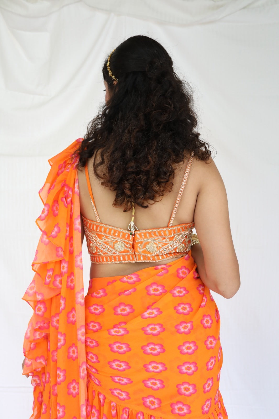 Floral printed orange pre stitched ruffle sari with a hand embroidered blouse