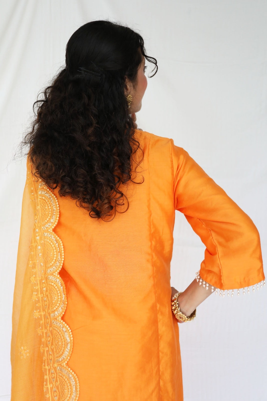 Orange chanderi kurta set with a hand embroidered yoke, intricate pearl detailing on the sleeves with an embellished scallop dupatta