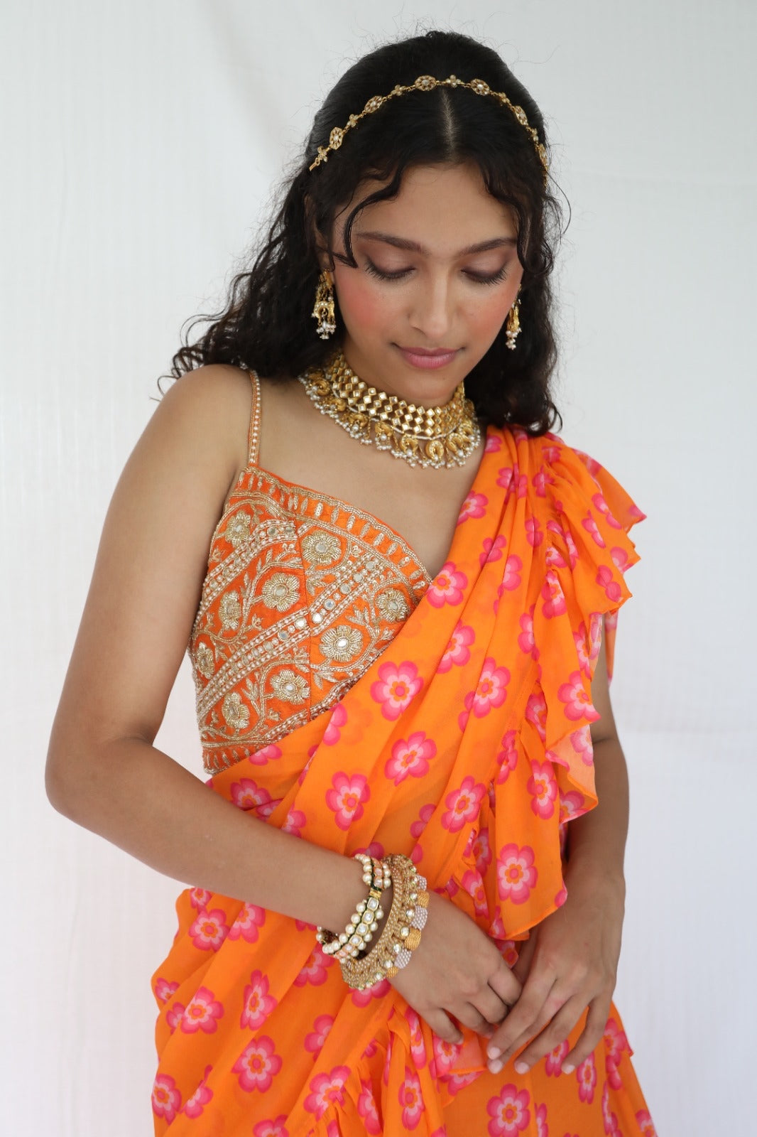 Floral printed orange pre stitched ruffle sari with a hand embroidered blouse