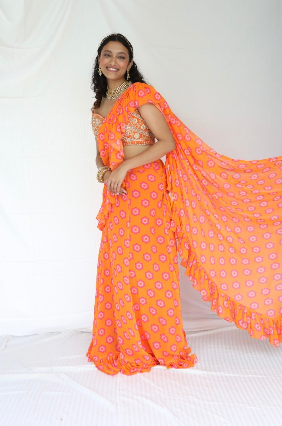 Floral printed orange pre stitched ruffle sari with a hand embroidered blouse