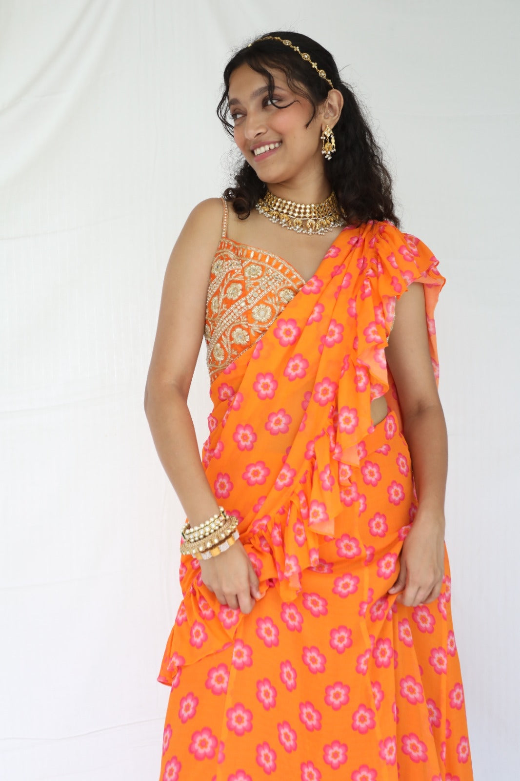 Floral printed orange pre stitched ruffle sari with a hand embroidered blouse