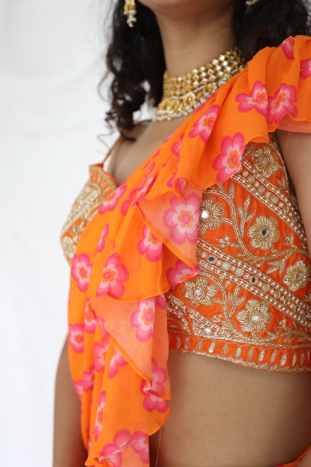 Floral printed orange pre stitched ruffle sari with a hand embroidered blouse