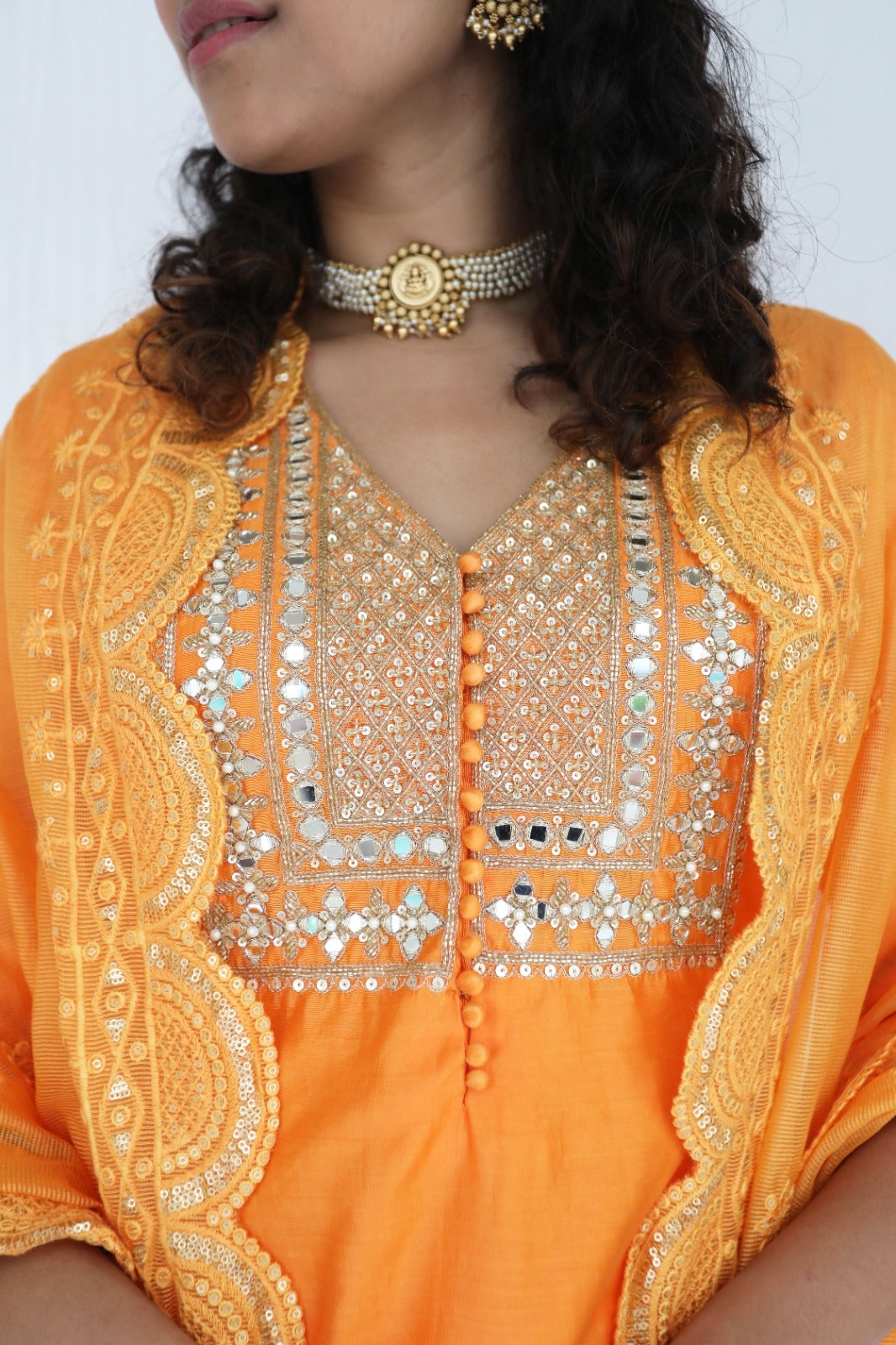 Orange chanderi kurta set with a hand embroidered yoke, intricate pearl detailing on the sleeves with an embellished scallop dupatta