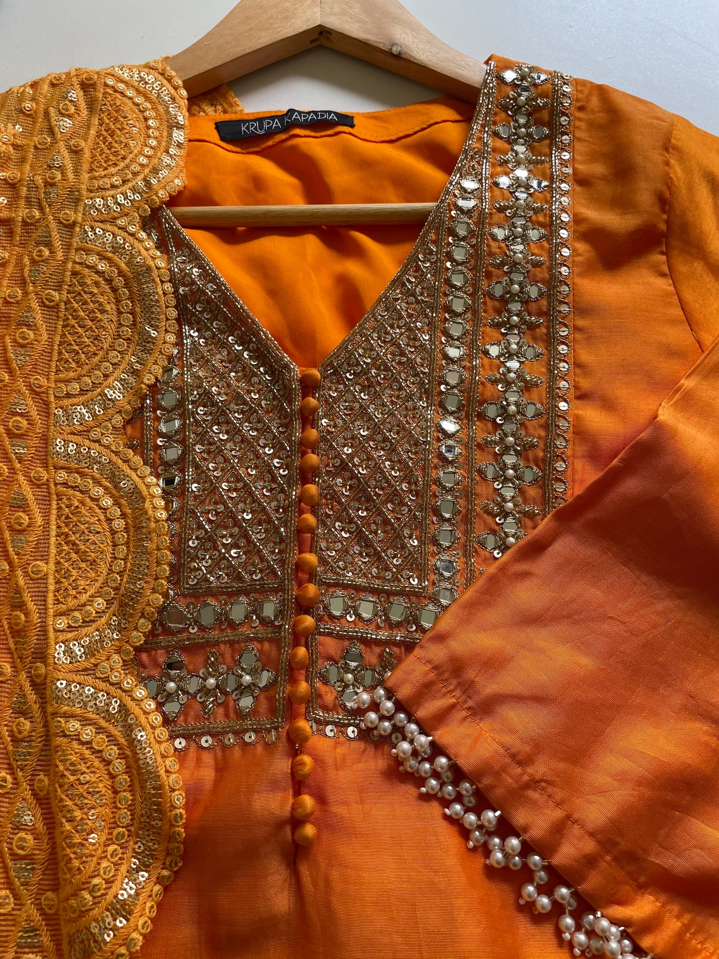 Orange chanderi kurta set with a hand embroidered yoke, intricate pearl detailing on the sleeves with an embellished scallop dupatta