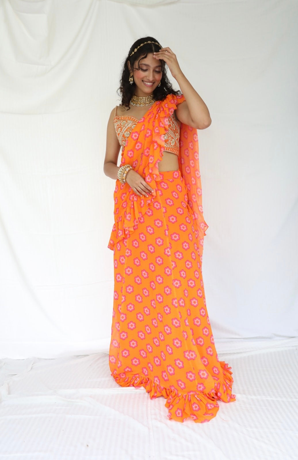 Floral printed orange pre stitched ruffle sari with a hand embroidered blouse