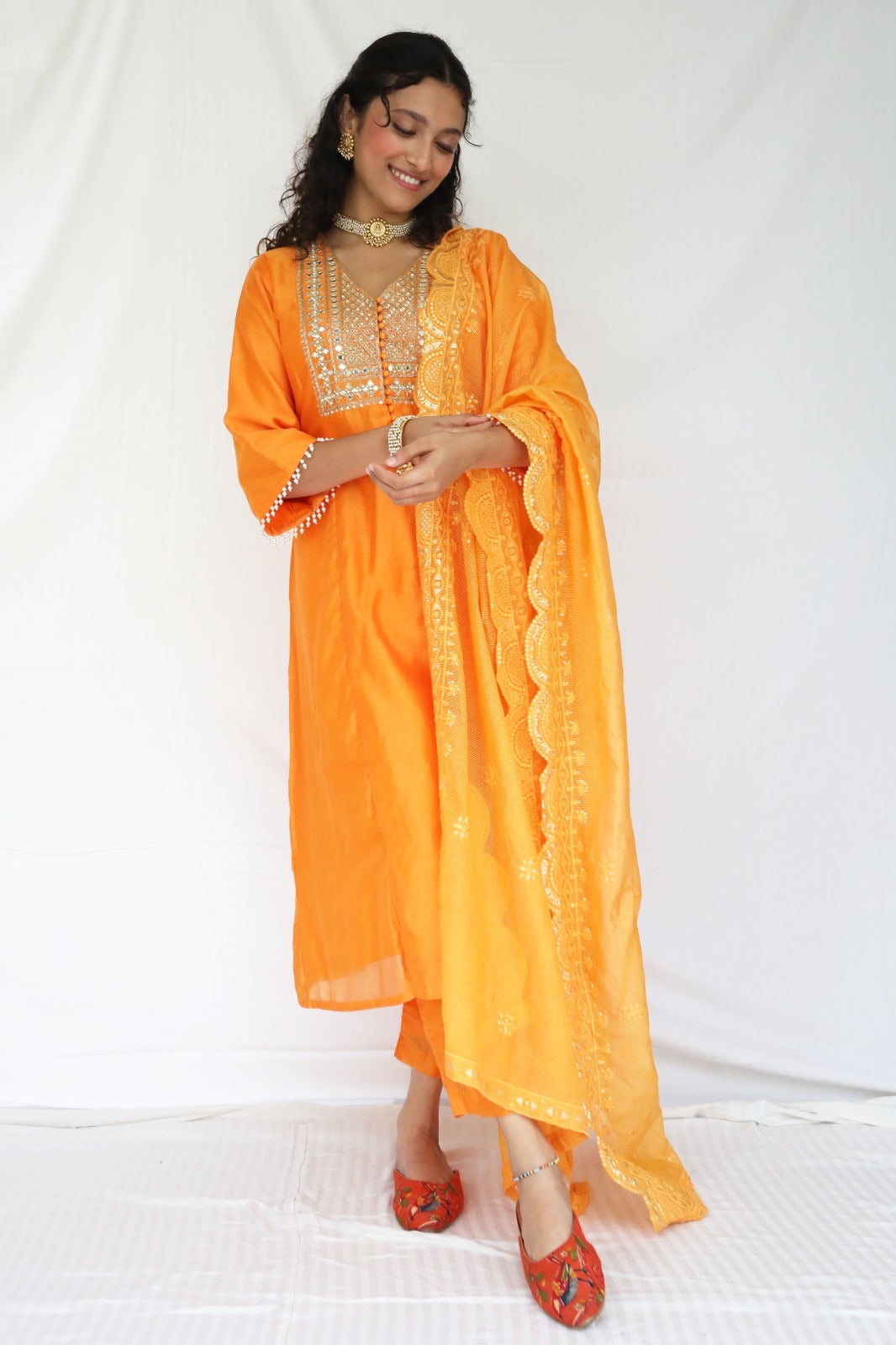 Orange chanderi kurta set with a hand embroidered yoke, intricate pearl detailing on the sleeves with an embellished scallop dupatta