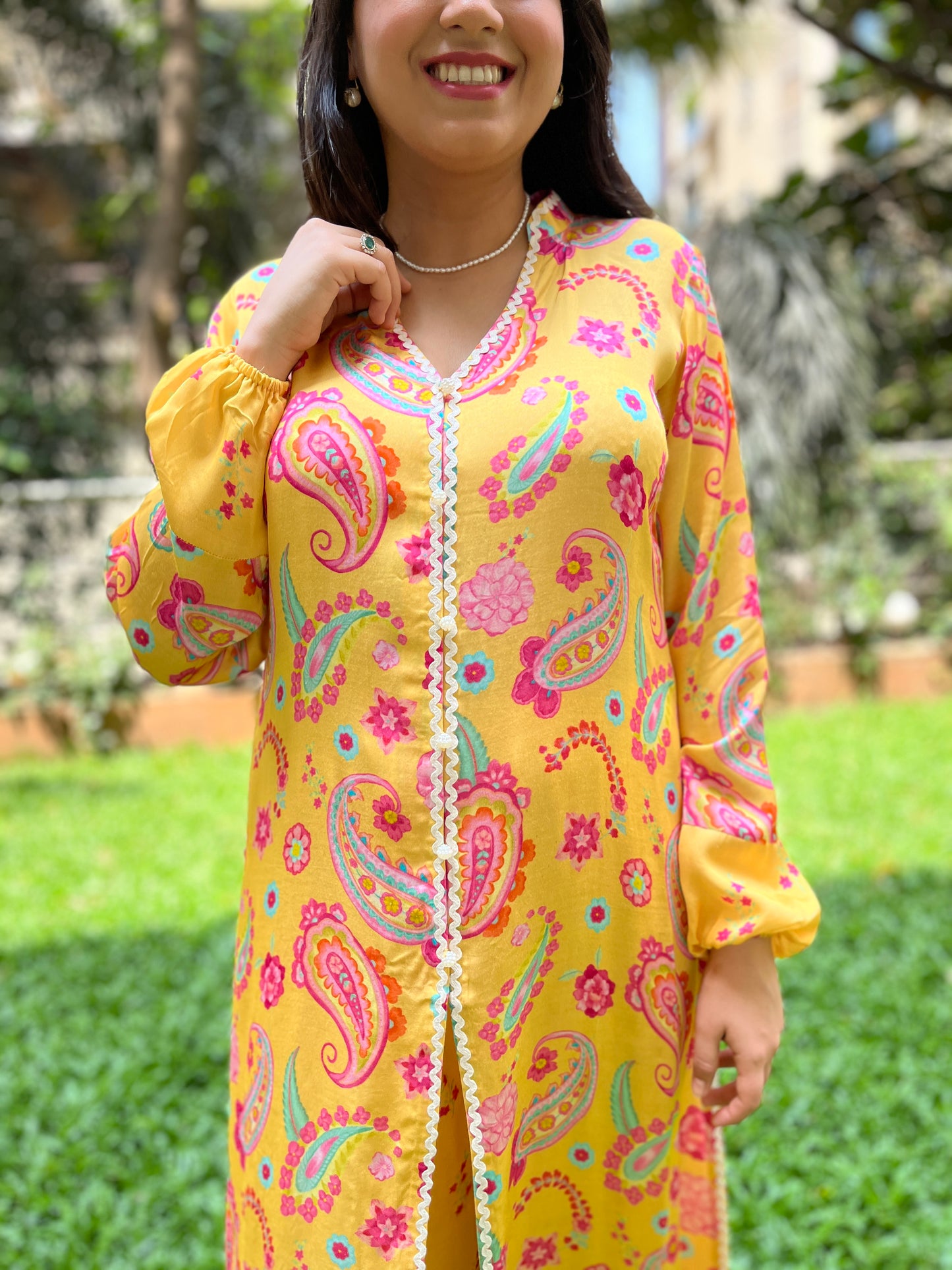 Yellow paisley printed kurta with intricate lace detailing and floral printed pyjama pants