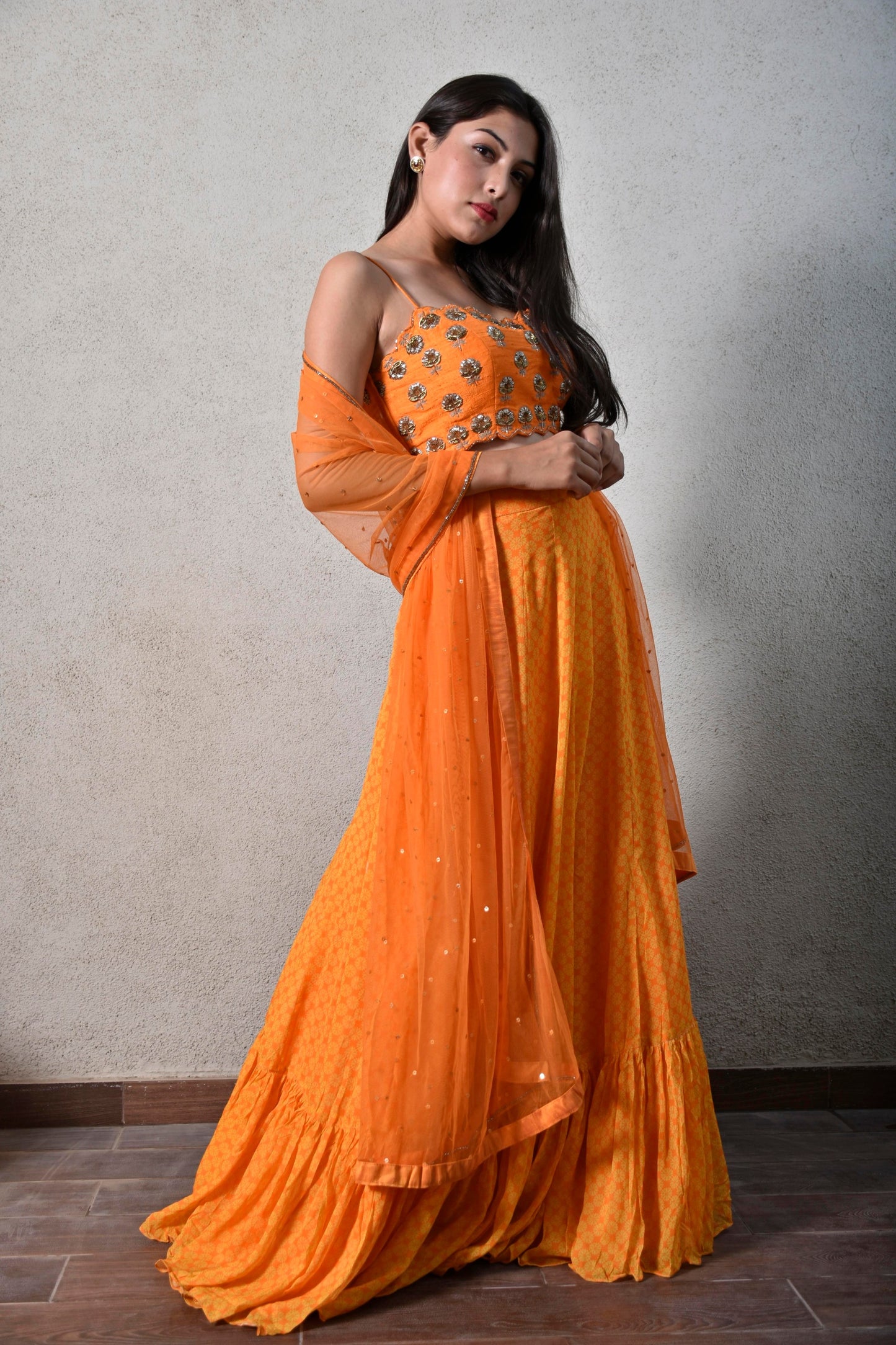 Yellow orange geometric floral printed ruffle skirt with a hand embroidered strappy blouse and dupatta