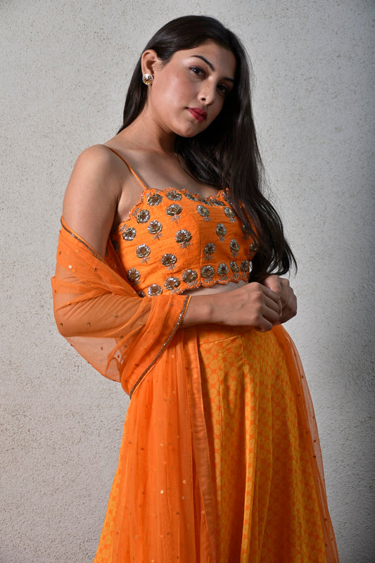 Yellow orange geometric floral printed ruffle skirt with a hand embroidered strappy blouse and dupatta