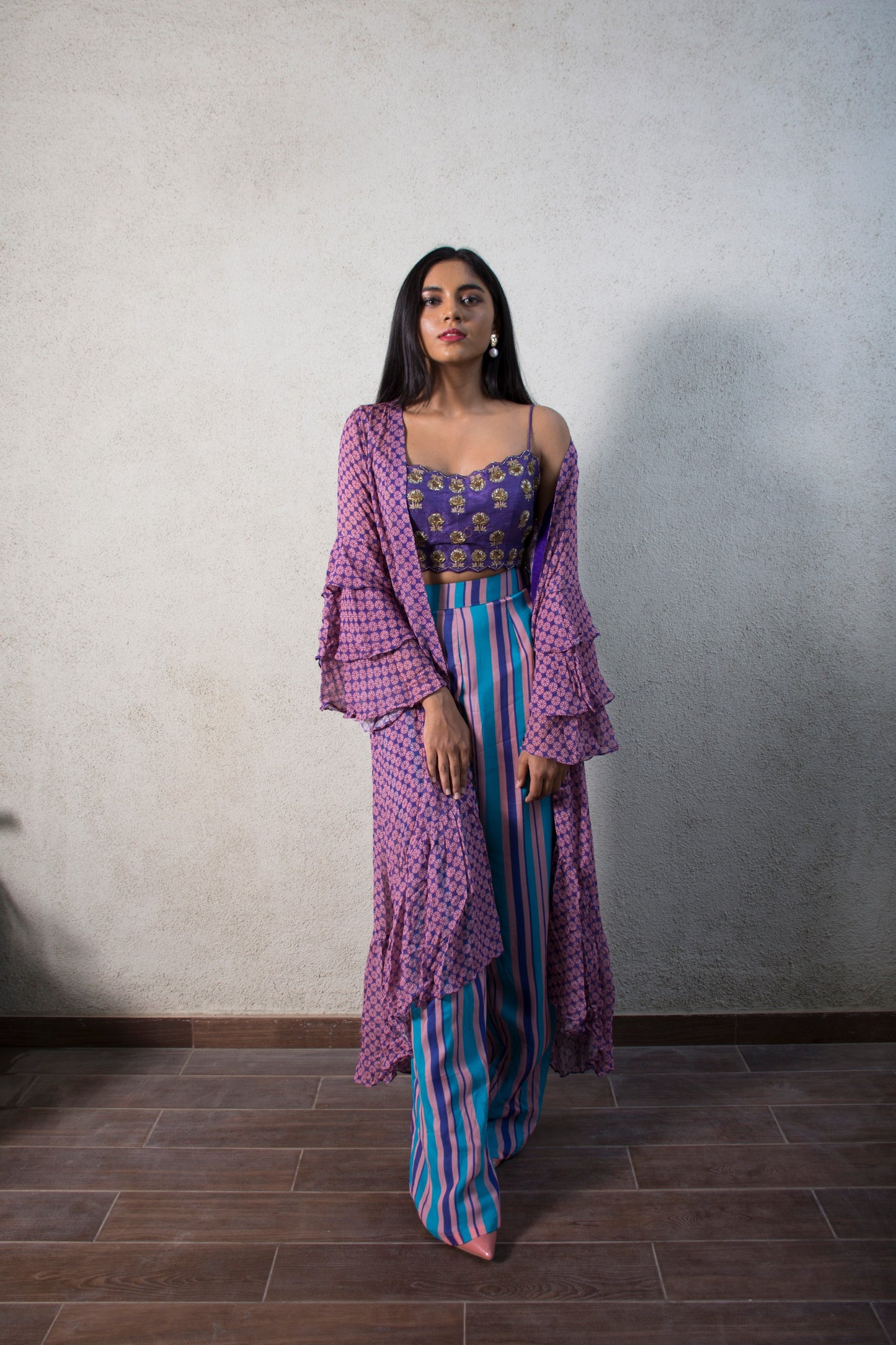 Hand embroidered purple blouse with a striped pant and geometric floral ruffle cape