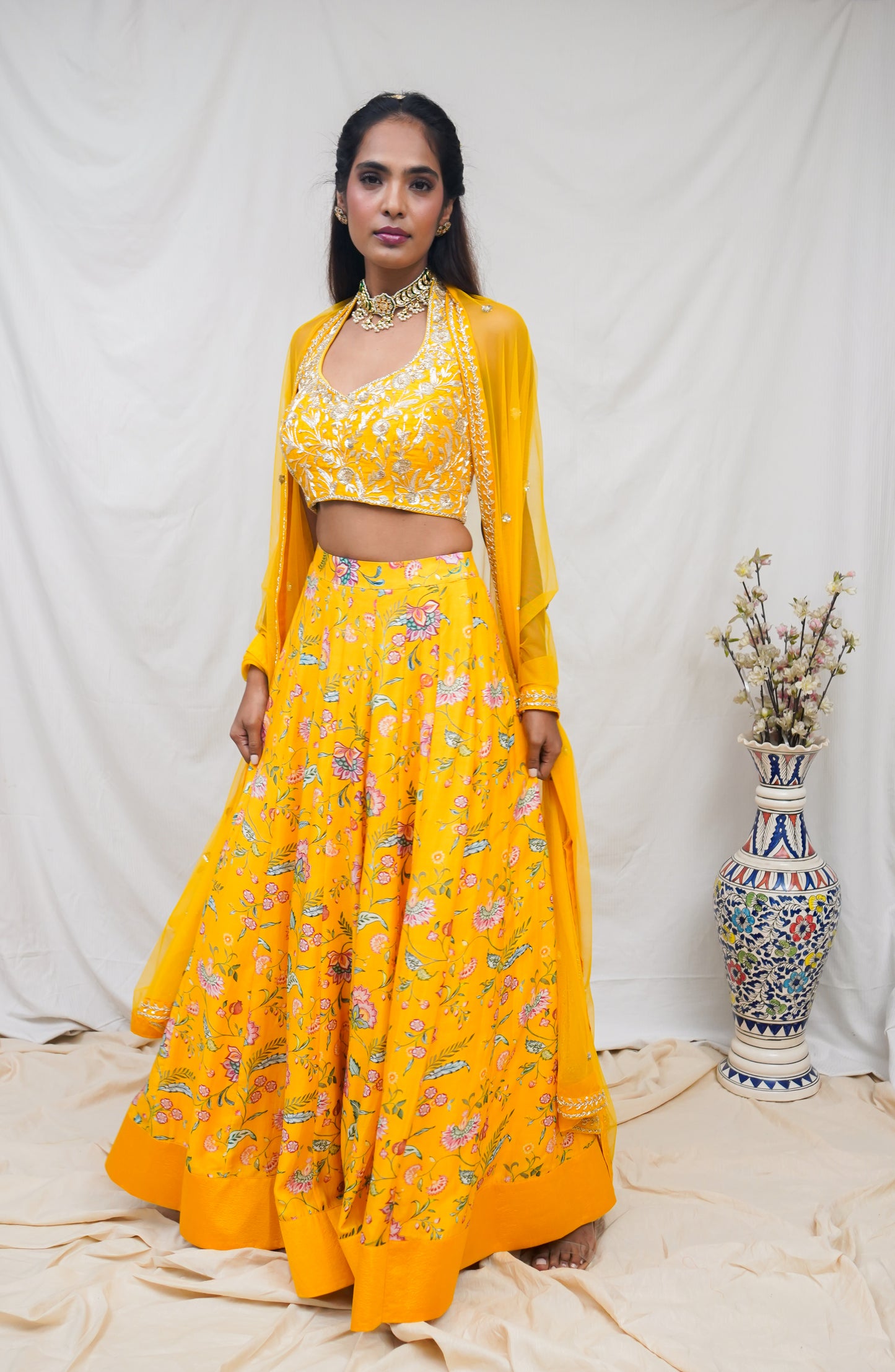 Hand embroidered yellow halter blouse and dupatta with a high waisted floral printed lehenga