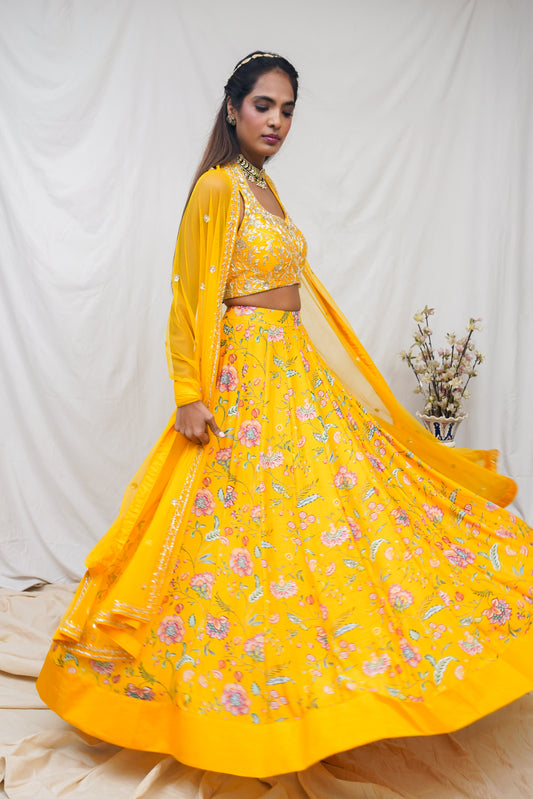 Hand embroidered yellow halter blouse and dupatta with a high waisted floral printed lehenga