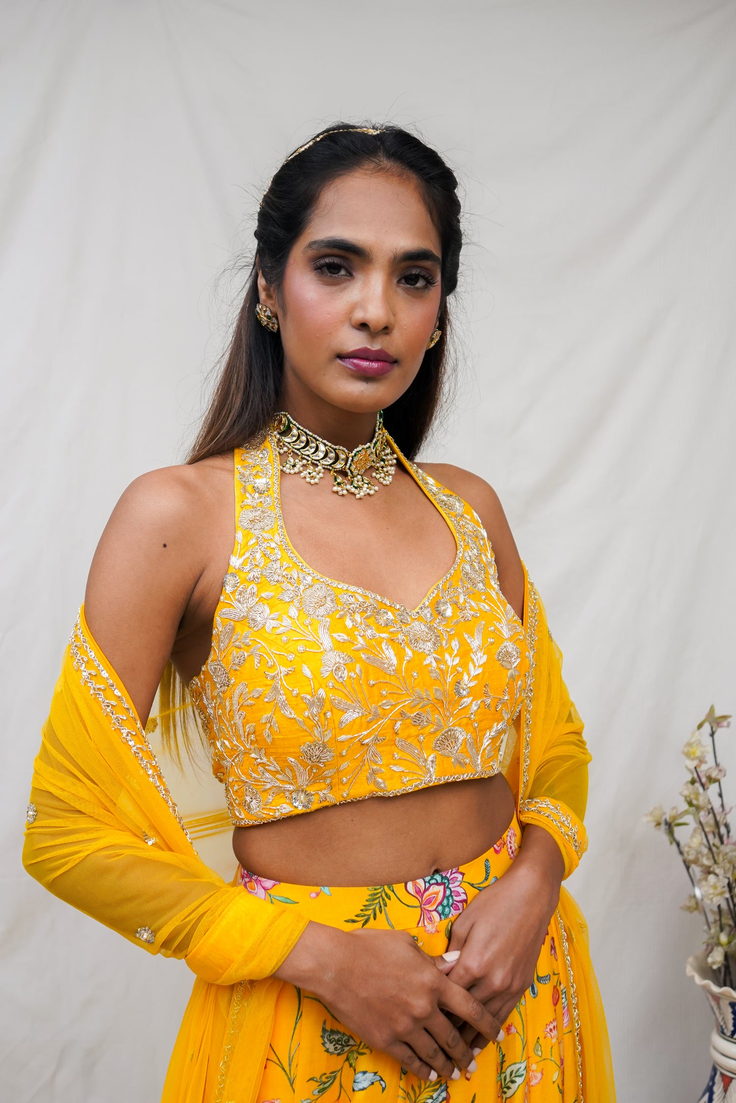 Hand embroidered yellow halter blouse and dupatta with a high waisted floral printed lehenga