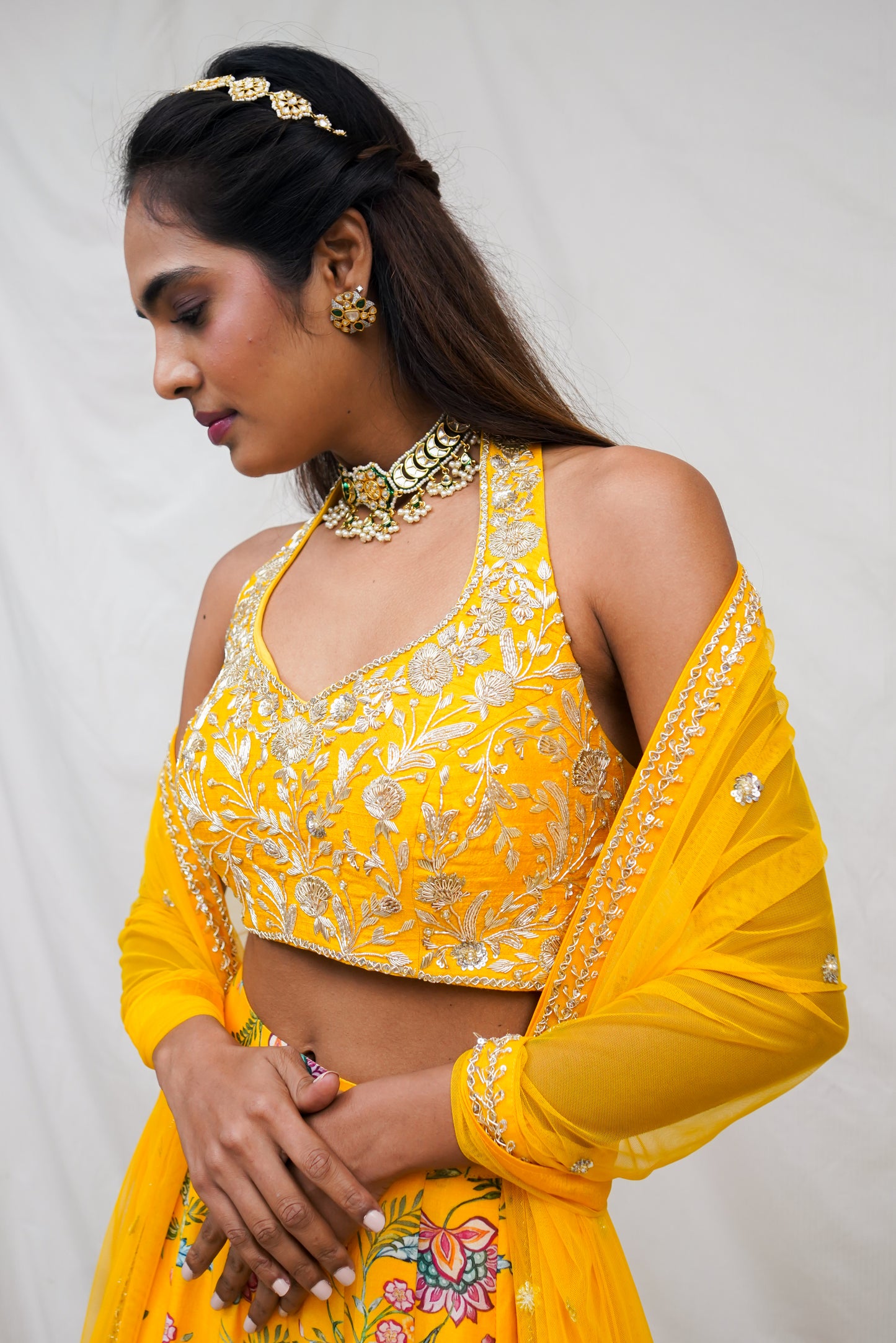 Hand embroidered yellow halter blouse and dupatta with a high waisted floral printed lehenga