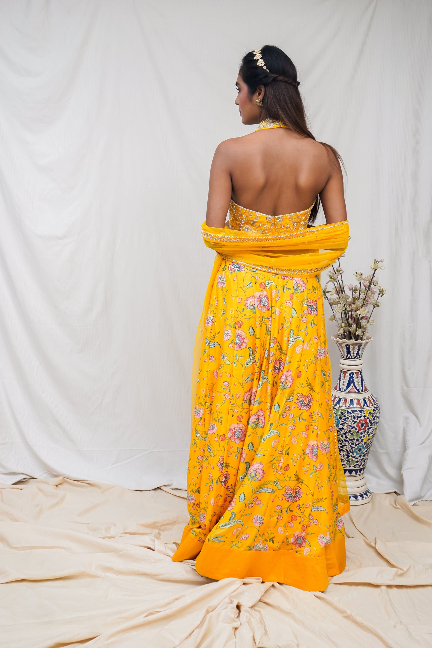 Hand embroidered yellow halter blouse and dupatta with a high waisted floral printed lehenga