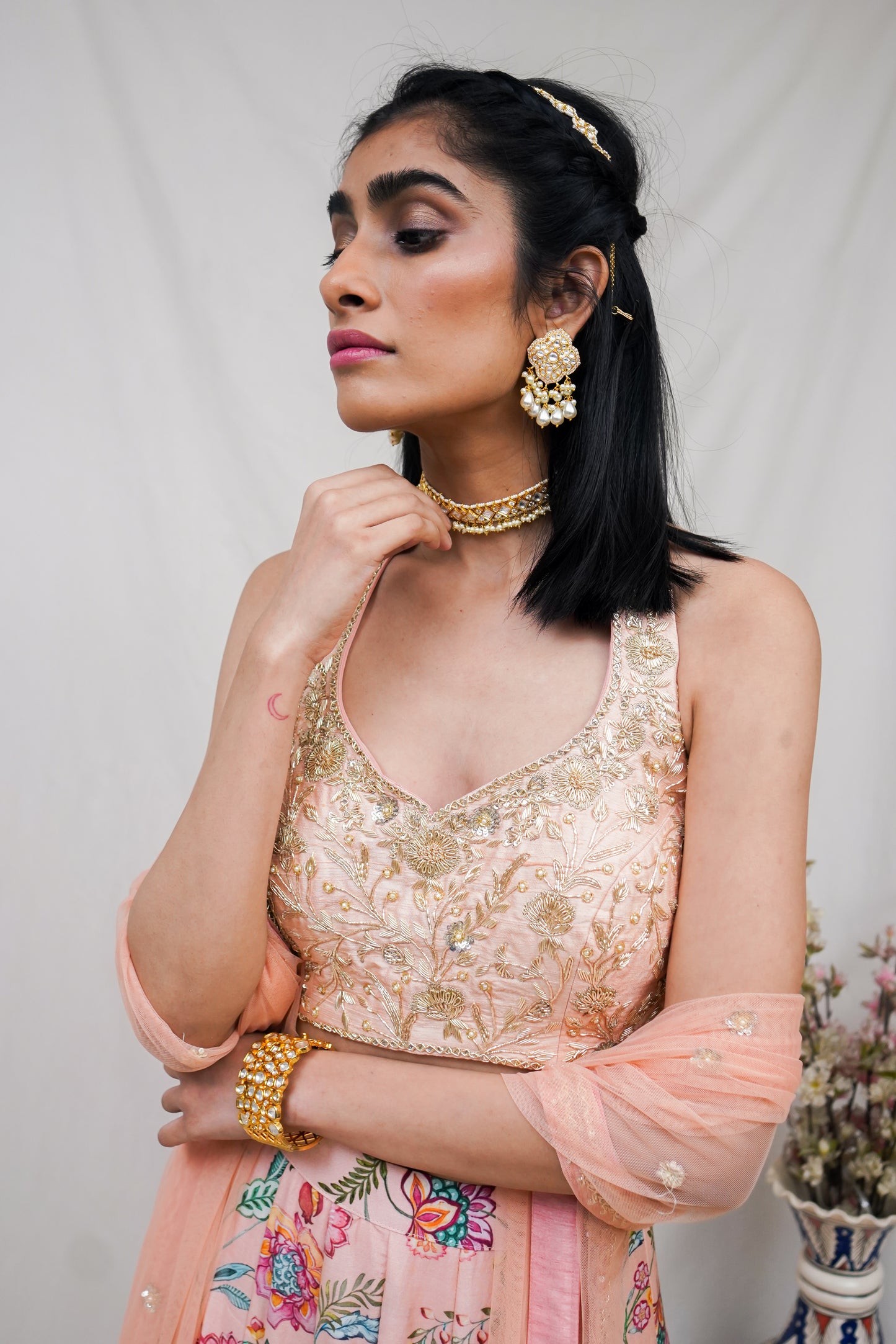 Hand embroidered peach halter blouse and dupatta with a high waisted floral printed lehenga