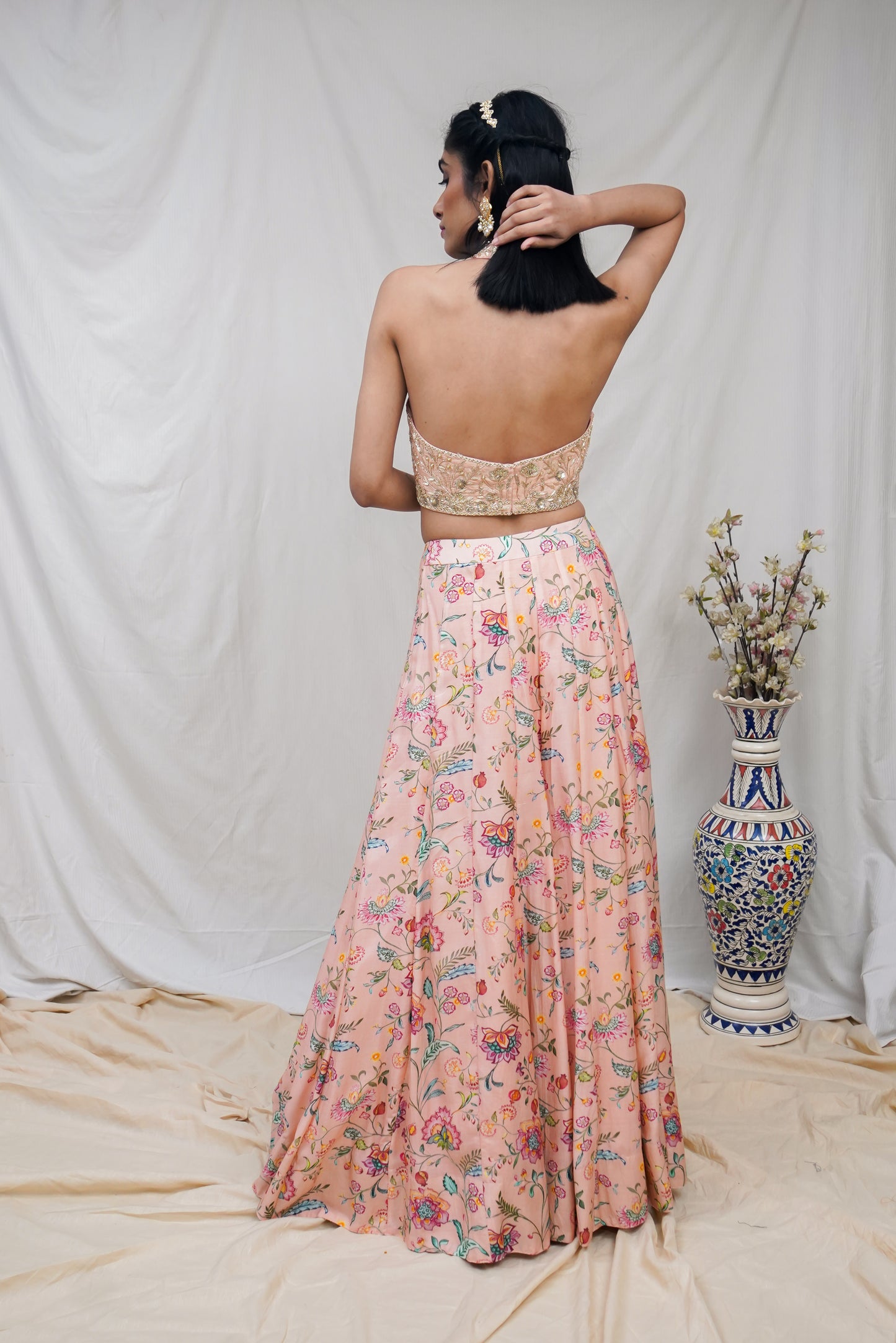 Hand embroidered peach halter blouse and dupatta with a high waisted floral printed lehenga