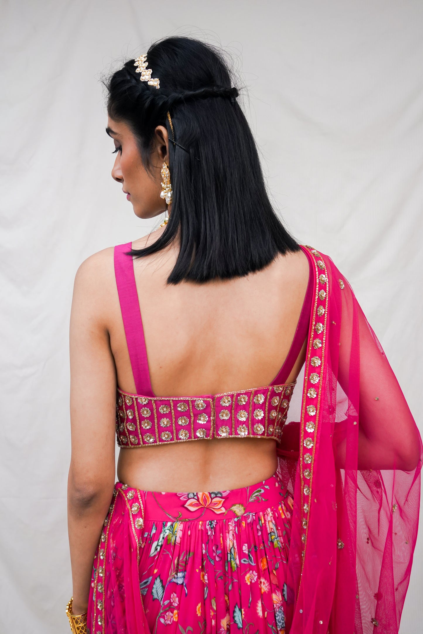 Rani pink hand embroidered blouse and dupatta with a high waisted floral printed lehenga