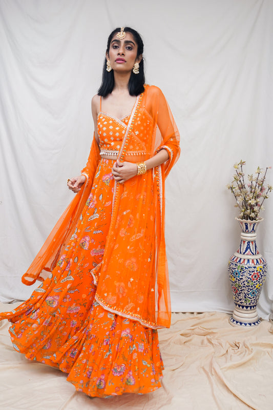 Hand embroidered orange wrap blouse and dupatta with a high waisted floral printed lehenga