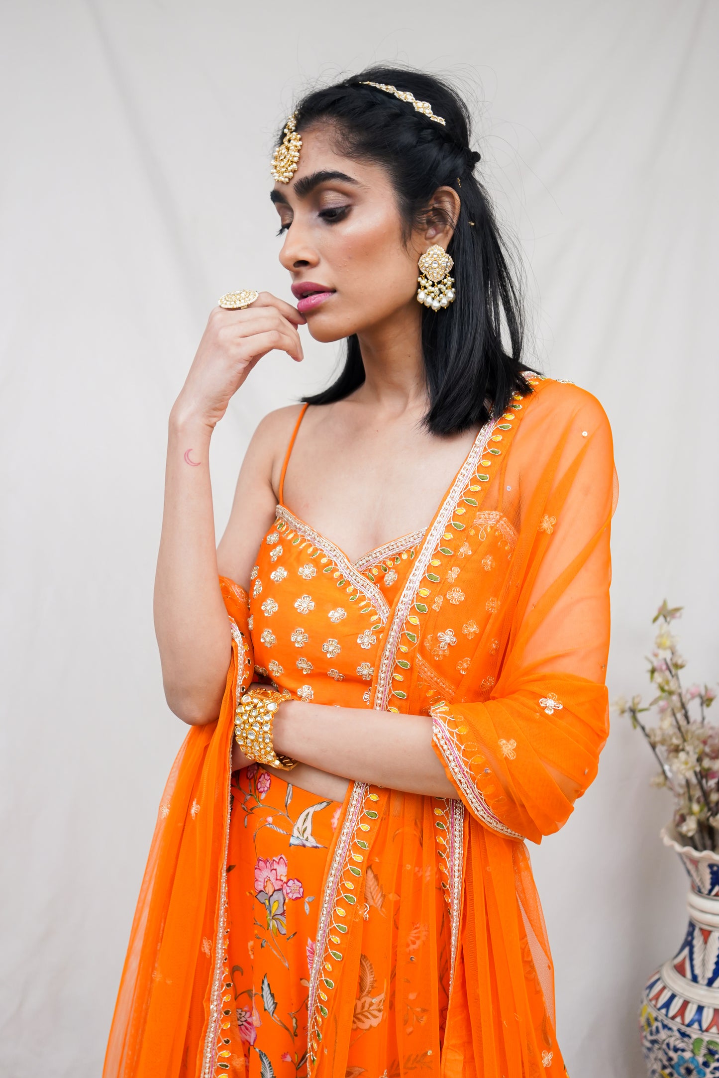 Hand embroidered orange wrap blouse and dupatta with a high waisted floral printed lehenga