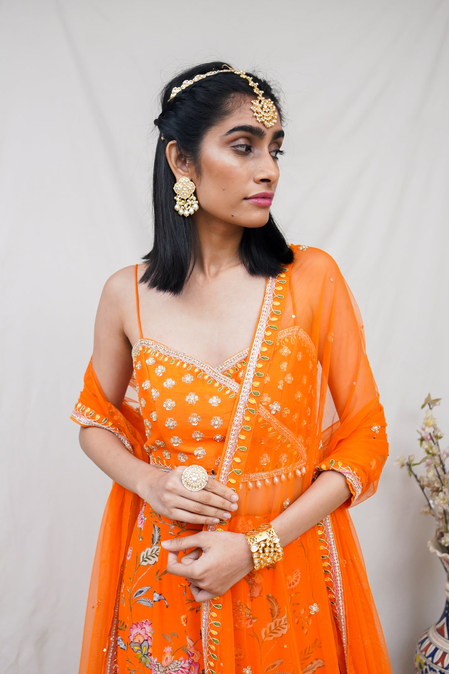 Hand embroidered orange wrap blouse and dupatta with a high waisted floral printed lehenga