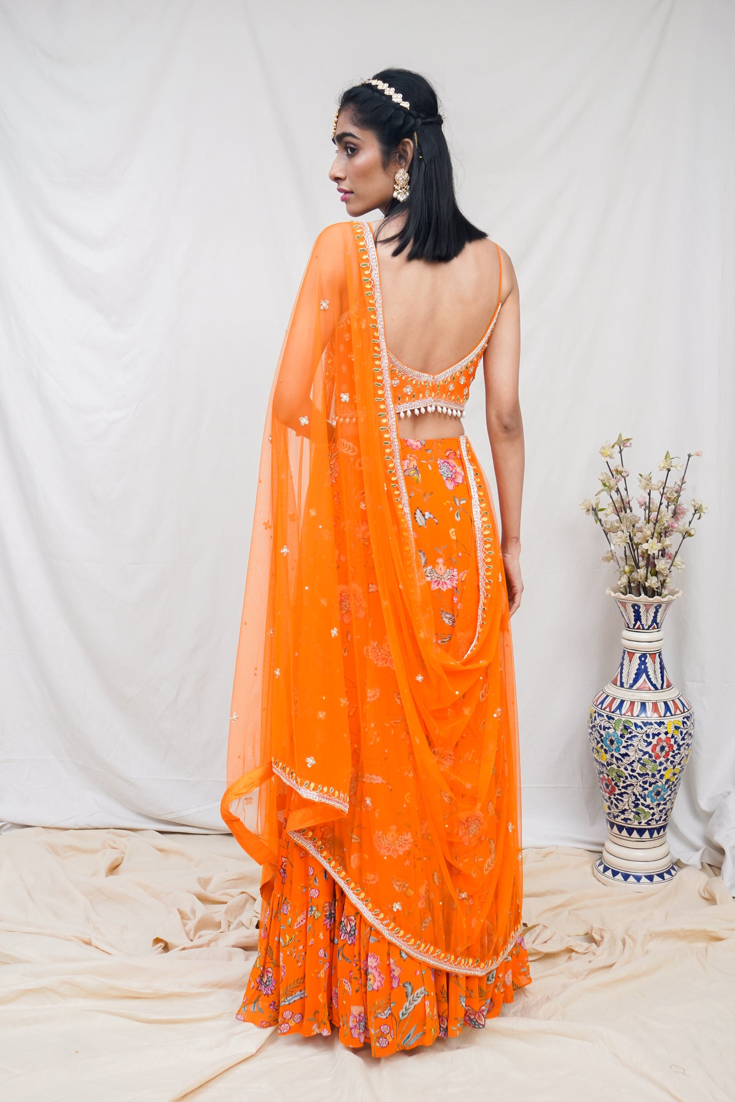 Hand embroidered orange wrap blouse and dupatta with a high waisted floral printed lehenga