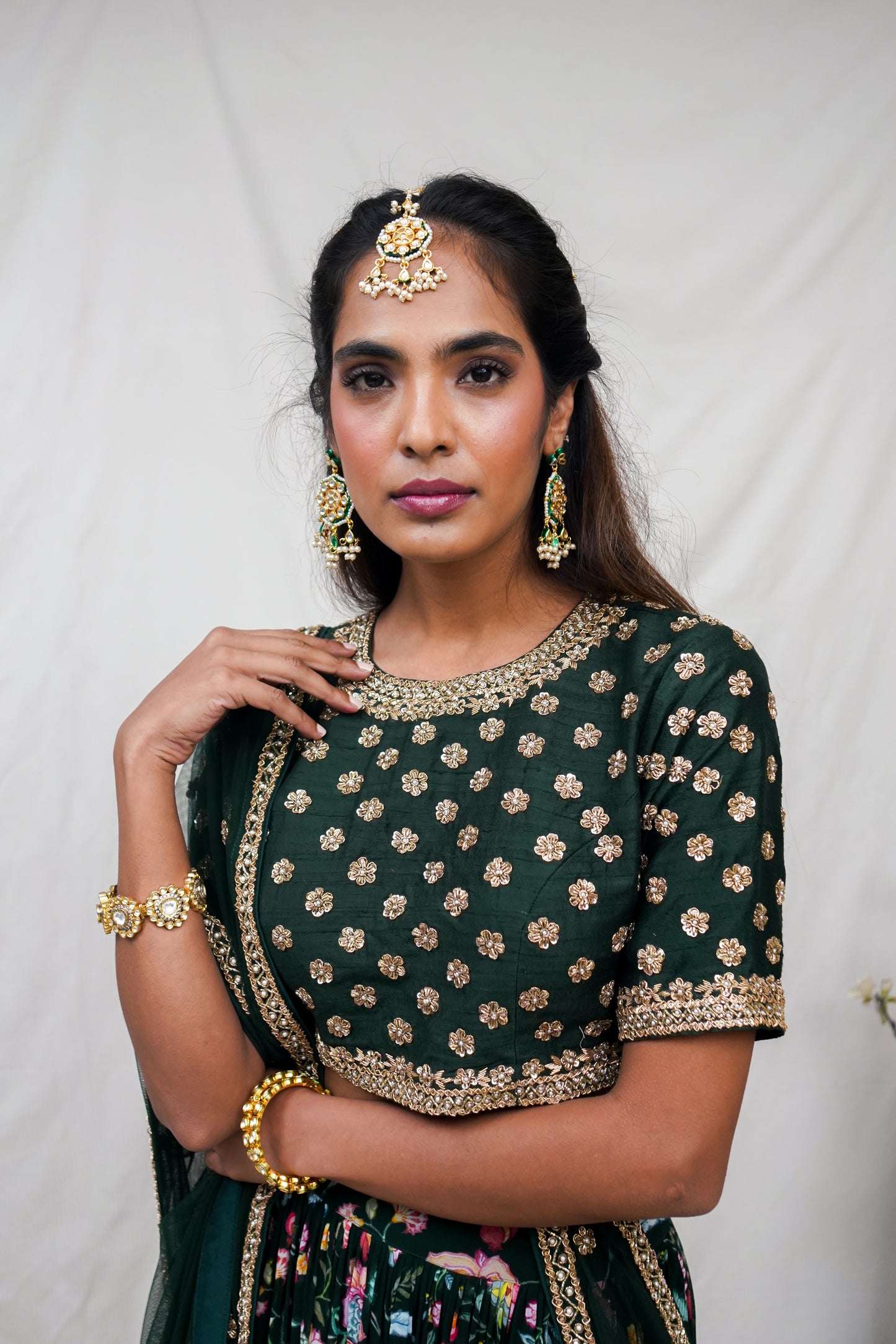 Bottle green hand embroidered blouse and dupatta with a high waisted floral printed lehenga