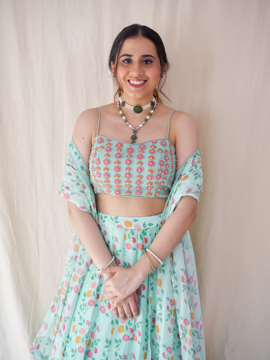 Hand embroidered ice blue blouse with a high waisted floral printed lehenga and dupatta