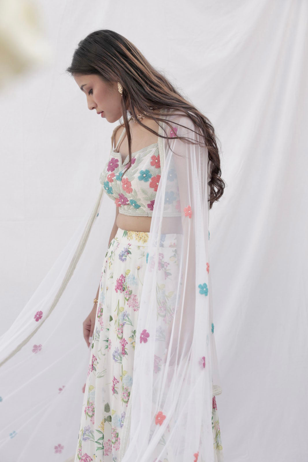 Ivory printed lehenga with a colorful hand embroidered blouse and dupatta