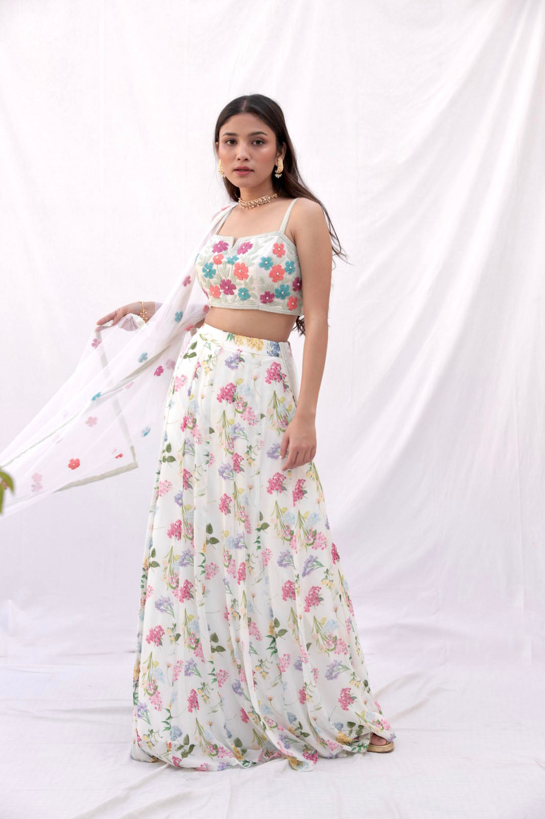 Ivory printed lehenga with a colorful hand embroidered blouse and dupatta